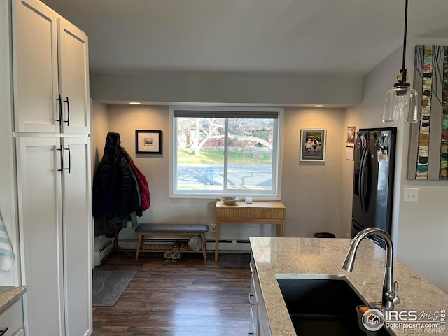 kitchen featuring refrigerator with ice dispenser, a sink, dark wood-style floors, light stone counters, and white cabinets
