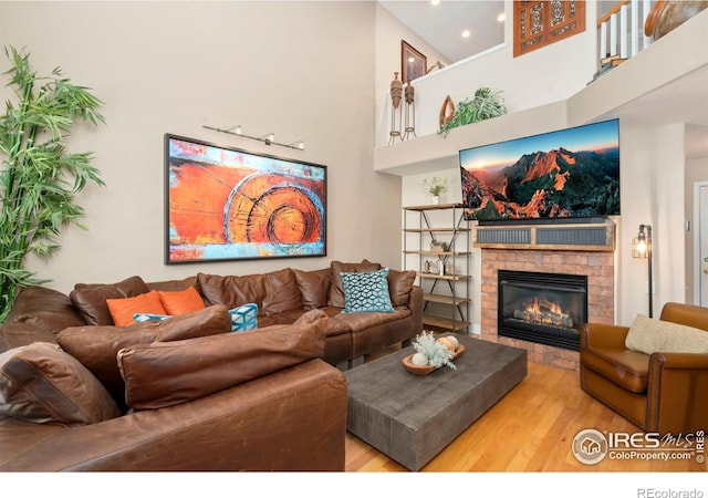 5125 Stetson Creek Ct Unit D, Fort Collins, CO 80528 - living room featuring wood finished floors, a glass covered fireplace, a towering ceiling, and recessed lighting