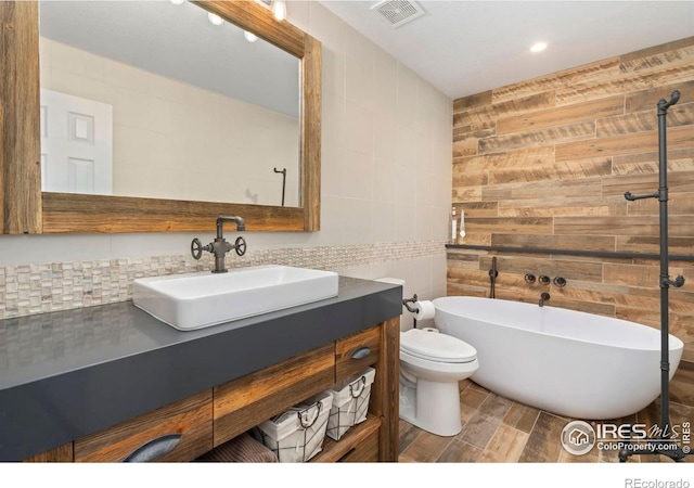 5125 Stetson Creek Ct Unit D, Fort Collins, CO 80528 - full bathroom with tile walls, a soaking tub, vanity, toilet, and wood finished floors