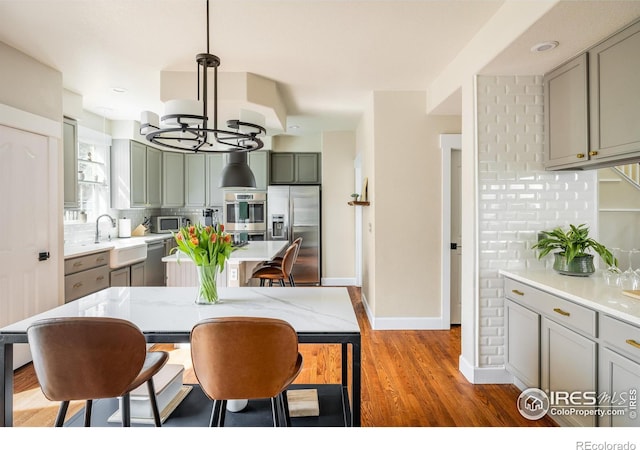 301 Indian Peaks Trl W, Lafayette, CO 80026 - kitchen featuring light countertops, a sink, light wood-style flooring, backsplash, and stainless steel appliances