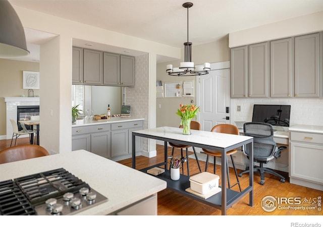 301 Indian Peaks Trl W, Lafayette, CO 80026 - kitchen with decorative backsplash, a chandelier, gray cabinetry, and stainless steel gas stovetop
