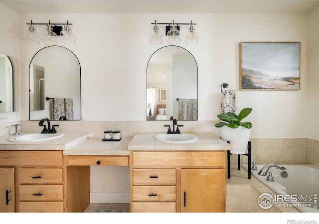 301 Indian Peaks Trl W, Lafayette, CO 80026 - bathroom with a sink, double vanity, and a relaxing tiled tub