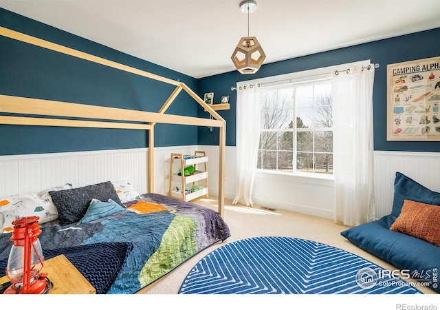 301 Indian Peaks Trl W, Lafayette, CO 80026 - carpeted bedroom with visible vents and a wainscoted wall