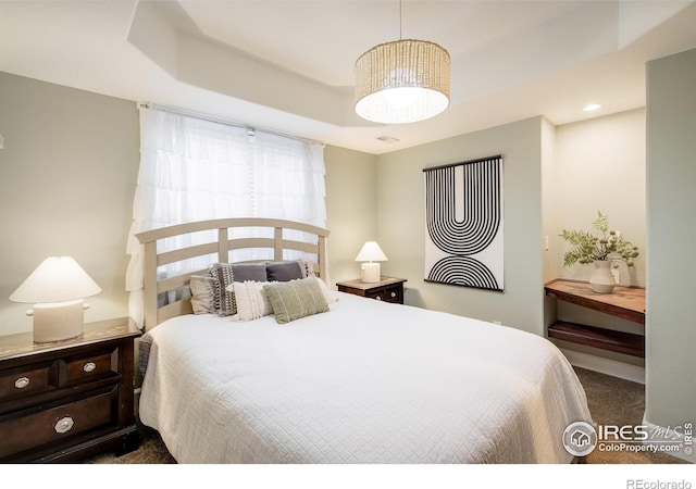 301 Indian Peaks Trl W, Lafayette, CO 80026 - bedroom featuring carpet floors, a tray ceiling, and visible vents