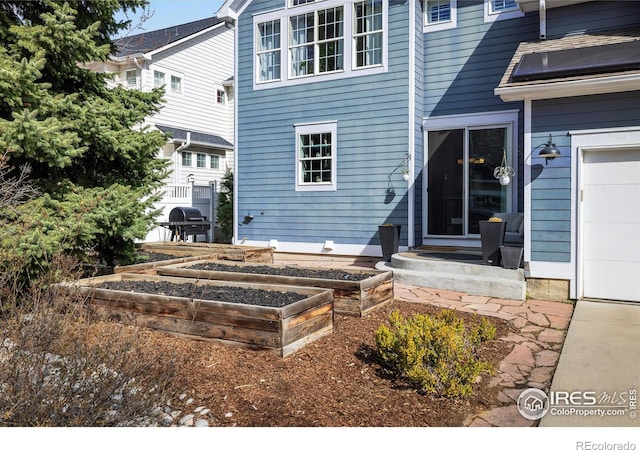 301 Indian Peaks Trl W, Lafayette, CO 80026 - back of house with a garage and a garden