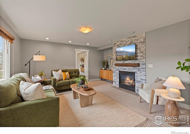 living area featuring light carpet, a fireplace, baseboards, and recessed lighting