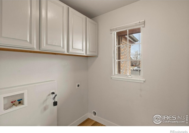 laundry room with hookup for a washing machine, wood finished floors, hookup for an electric dryer, baseboards, and cabinet space