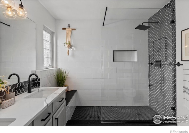 bathroom with a walk in shower, double vanity, and a sink