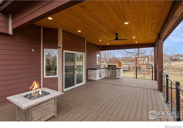 deck featuring an outdoor fire pit, ceiling fan, a grill, and area for grilling