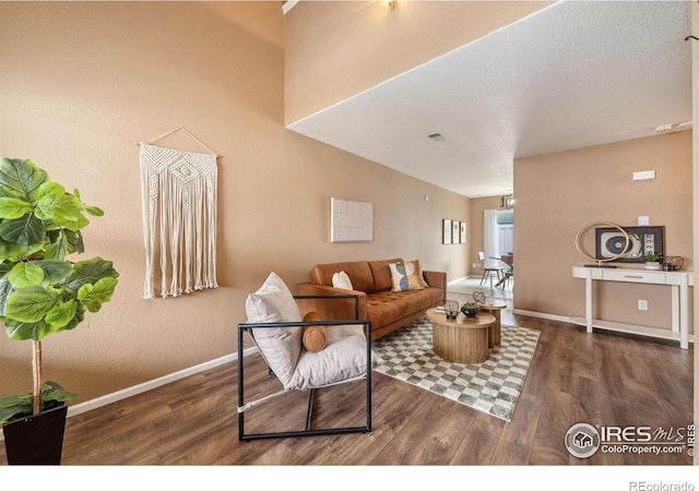 living area with visible vents, baseboards, and wood finished floors
