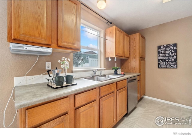 kitchen with baseboards, dishwasher, light countertops, and a sink