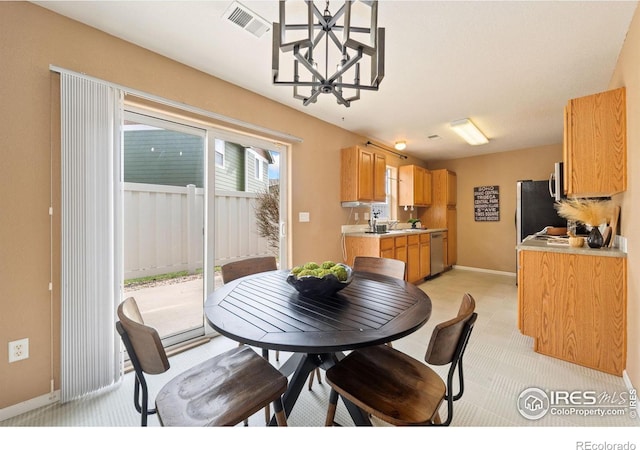 dining room featuring a chandelier, visible vents, baseboards, and light colored carpet