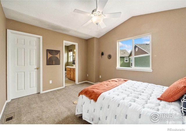 bedroom with baseboards, ensuite bath, a ceiling fan, lofted ceiling, and carpet