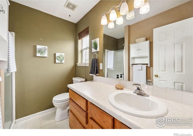 bathroom with vanity, tile patterned flooring, visible vents, toilet, and walk in shower
