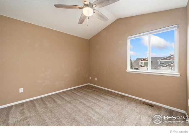 carpeted spare room featuring visible vents, baseboards, a ceiling fan, and vaulted ceiling