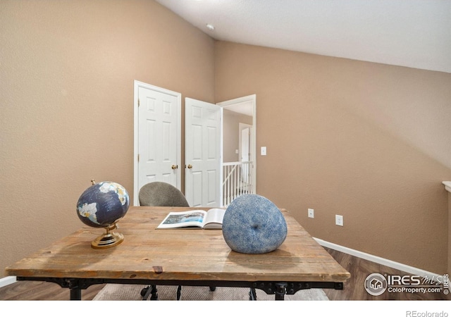 office space featuring wood finished floors, baseboards, and vaulted ceiling
