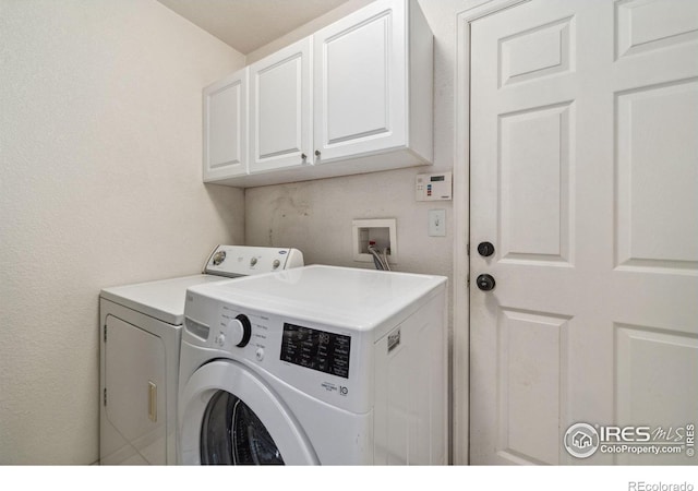 washroom with cabinet space and washer and clothes dryer