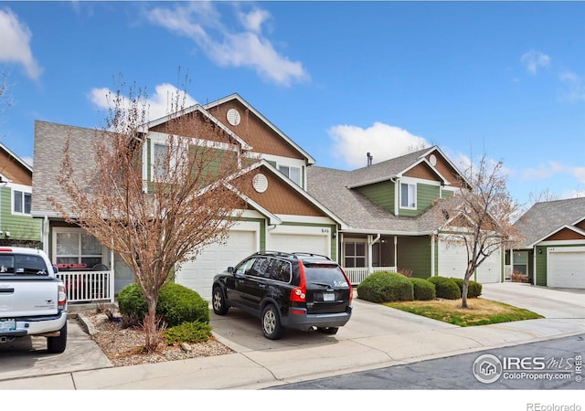 view of front of property with concrete driveway, roof with shingles, and an attached garage