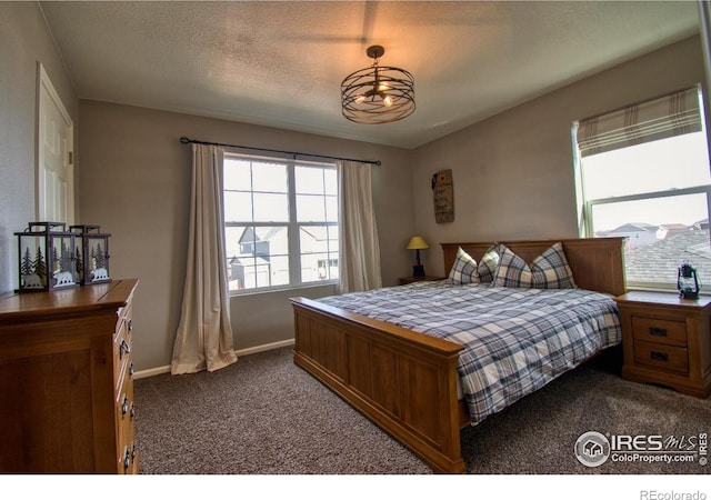 carpeted bedroom featuring baseboards and a textured ceiling