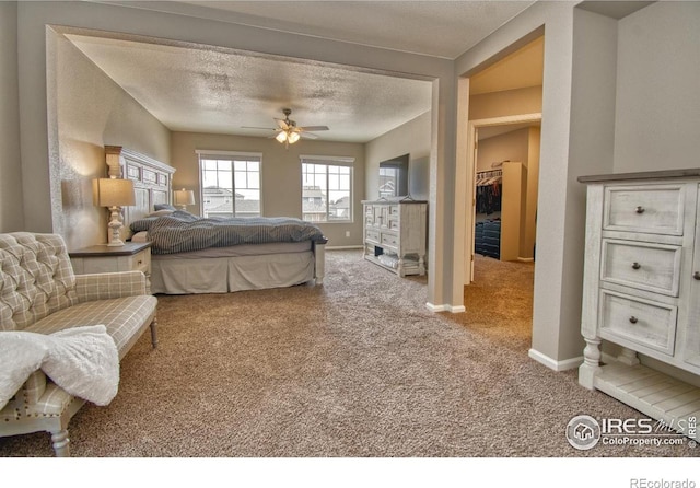 carpeted bedroom with baseboards, a textured ceiling, and a ceiling fan