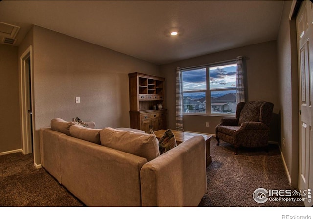 living area with baseboards and dark colored carpet