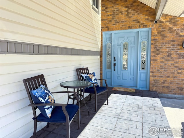 entrance to property featuring brick siding