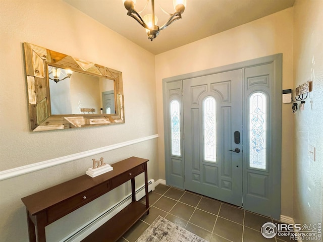 entryway featuring baseboard heating, baseboards, an inviting chandelier, and dark tile patterned floors