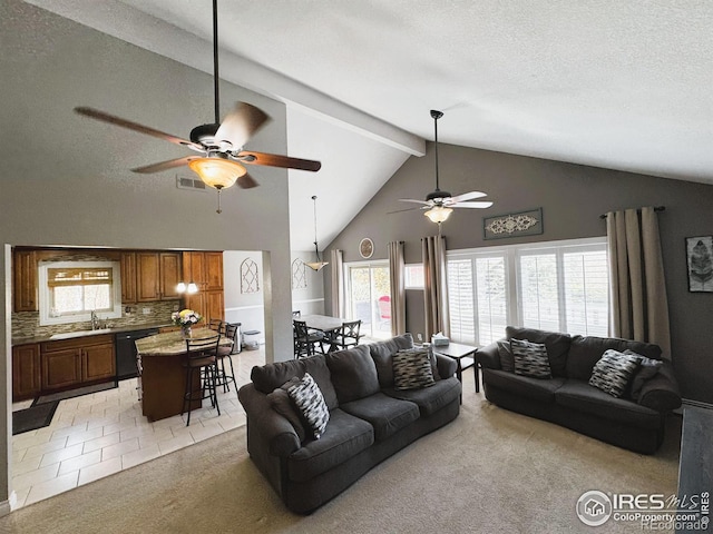 living room with light tile patterned flooring, beam ceiling, a ceiling fan, a textured ceiling, and light colored carpet
