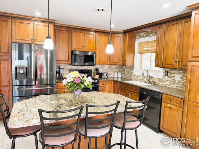 kitchen with a kitchen breakfast bar, a sink, visible vents, black appliances, and brown cabinetry