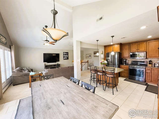 dining space with high vaulted ceiling, visible vents, a ceiling fan, a baseboard heating unit, and light tile patterned floors