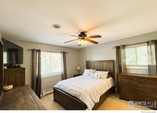 bedroom with a textured ceiling, visible vents, a ceiling fan, baseboard heating, and light carpet