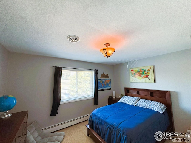 bedroom featuring a baseboard radiator, visible vents, and a textured ceiling