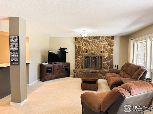 carpeted living room with a stone fireplace, baseboards, and a textured ceiling