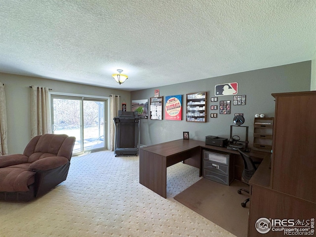 carpeted home office featuring a textured ceiling