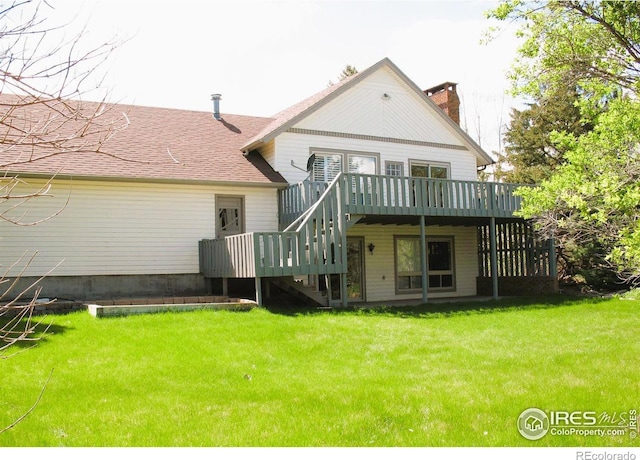 rear view of house with a chimney, stairway, a deck, roof with shingles, and a yard
