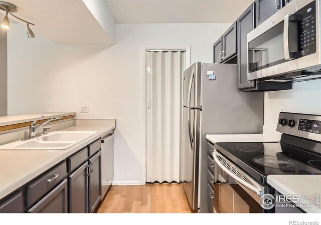 3790 Iris Ave Unit B, Boulder, CO 80301 - kitchen featuring appliances with stainless steel finishes, a sink, light countertops, light wood-style flooring, and baseboards
