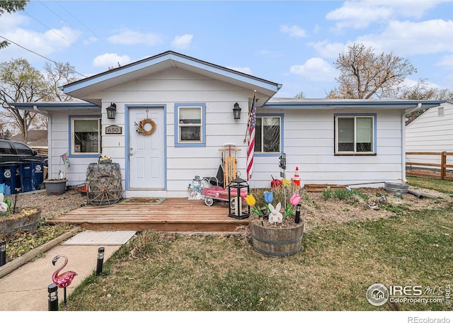 view of front of home featuring a front yard, fence, and a wooden deck