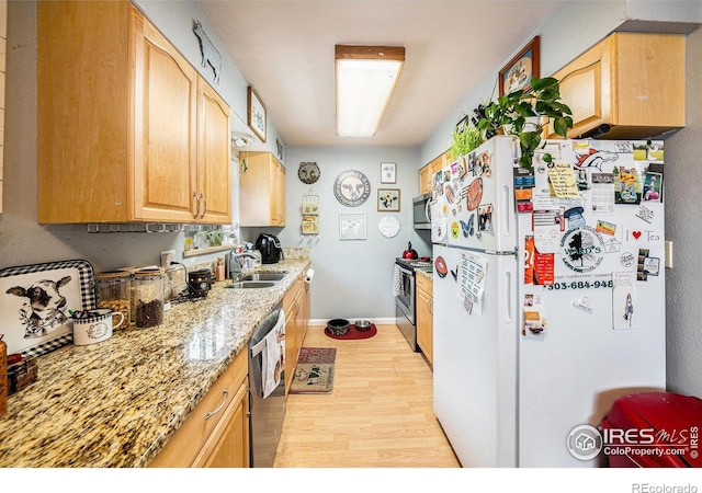 kitchen with light brown cabinetry, light wood-style flooring, a sink, and stainless steel appliances