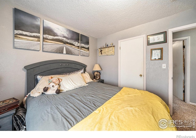 bedroom featuring a textured ceiling and carpet