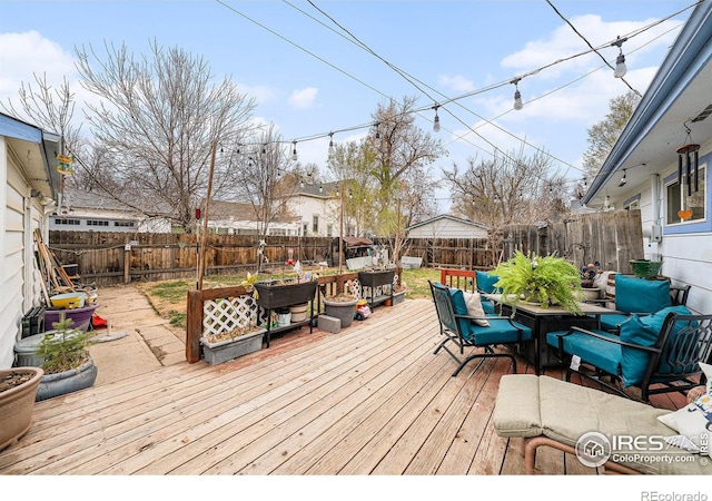 wooden deck featuring outdoor dining area and a fenced backyard