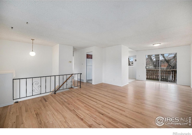 spare room with wood finished floors and a textured ceiling