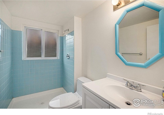 bathroom with toilet, a stall shower, and vanity