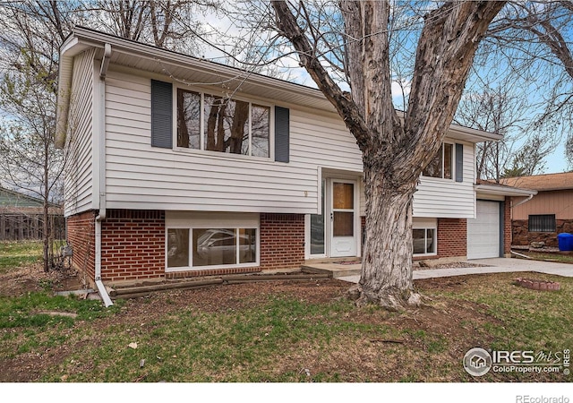 view of front of house featuring driveway, brick siding, and a garage