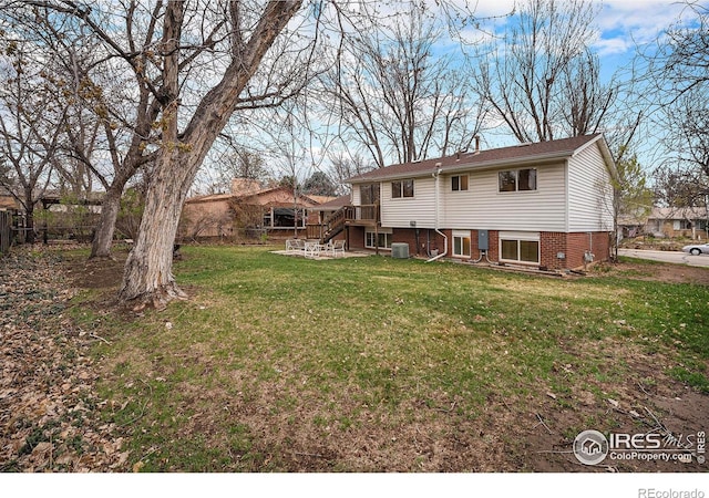 back of house featuring central air condition unit, fence, stairway, and a yard