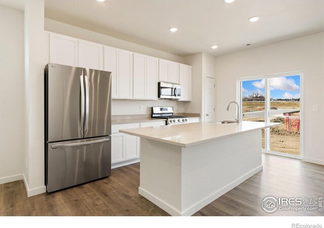 7153 Feather Reed Dr, Wellington, CO 80549 - kitchen featuring dark wood-type flooring, white cabinetry, a sink, and stainless steel appliances