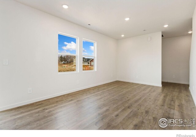 7153 Feather Reed Dr, Wellington, CO 80549 - spare room featuring baseboards, wood finished floors, and recessed lighting