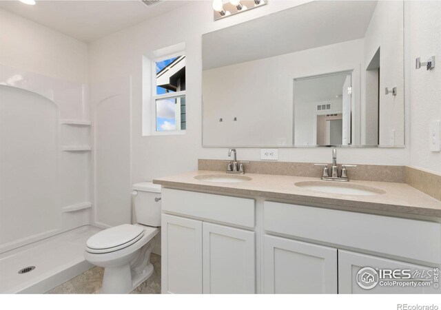7153 Feather Reed Dr, Wellington, CO 80549 - bathroom featuring double vanity, a sink, toilet, and a stall shower