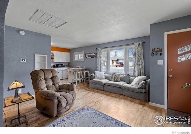 117 Welch Ave, Berthoud, CO 80513 - living room with attic access, light wood-type flooring, and a textured ceiling