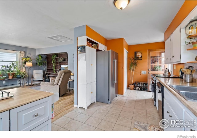 117 Welch Ave, Berthoud, CO 80513 - kitchen featuring appliances with stainless steel finishes, light countertops, white cabinets, light tile patterned floors, and a sink