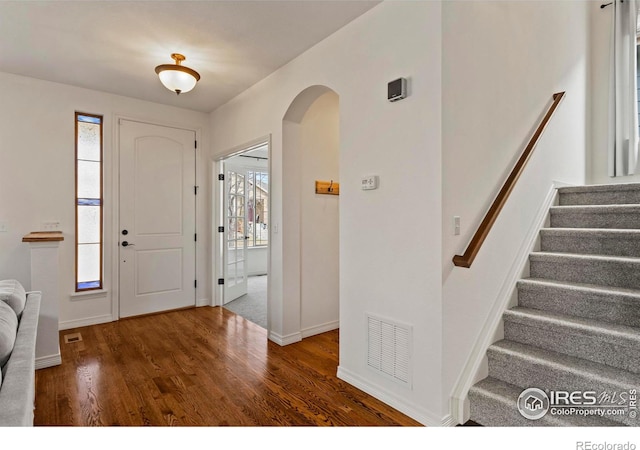 1827 Prairie Ridge Dr, Fort Collins, CO 80526 - entryway featuring stairway, baseboards, arched walkways, visible vents, and wood finished floors